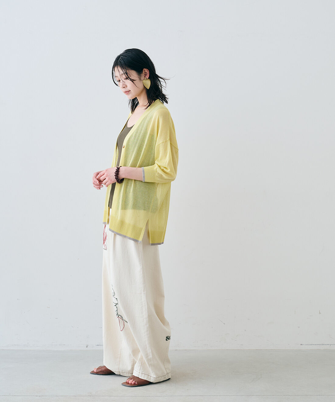 MEDE19F|アート刺繍をほどこした ワイドパンツ〈生成り〉とヴィンテージトライアングルイヤリングと配色ラインのシアーニット カーディガンと配色ラインのシアーニット カーディガンのコーディネート